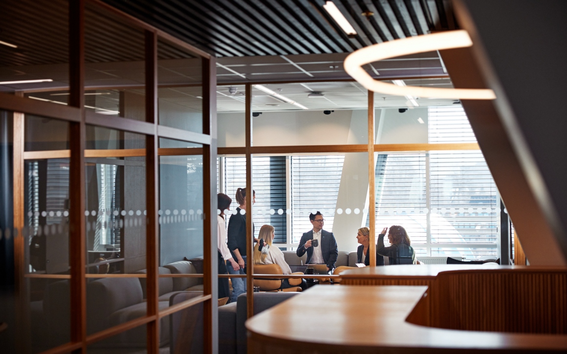 Kollegor pratar i kontorsmiljö.