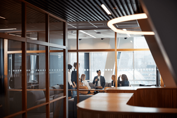 Kollegor pratar i kontorsmiljö.