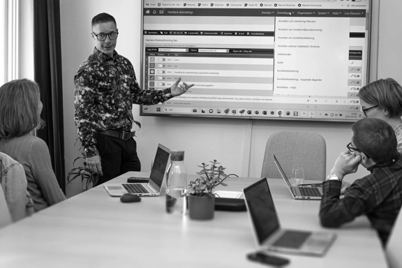 Människor framför en väggmonterad skärm